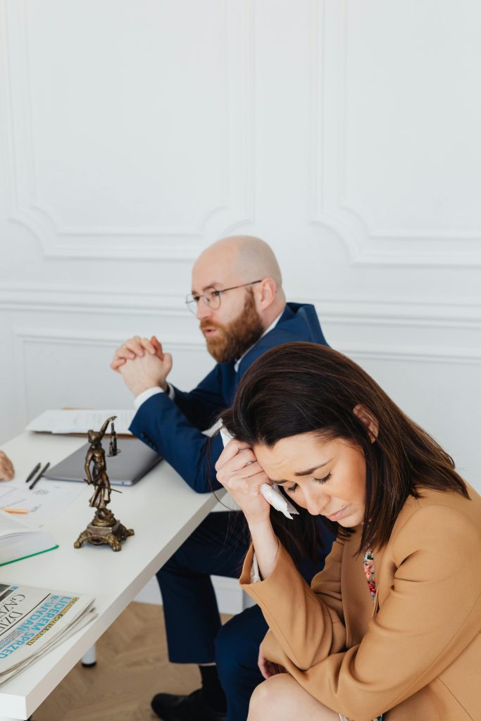 A serious discussion between a lawyer and a client, reflecting stress and emotion.